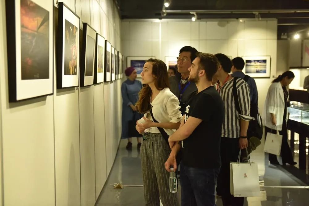 中外摄影家在观看丝路国家青少年国际摄影竞赛获奖作品展